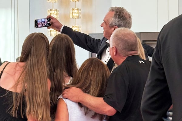 Health and Human Services Secretary Robert F. Kennedy Jr. takes a photo with people at the opening night of "Les Miserables," at the Kennedy Center, Wednesday, June 11, 2025, in Washington, that President Donald Trump and first lady Melania Trump were also attending. (AP Photo/Alex Brandon)