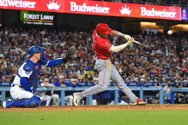Los Angeles Angels' Logan O'Hoppe, hits a three-run home run as Los Angeles Dodgers catcher Dalton Rushing watches during the seventh inning of a baseball game Saturday, May 17, 2025, in Los Angeles. (AP Photo/Mark J. Terrill)