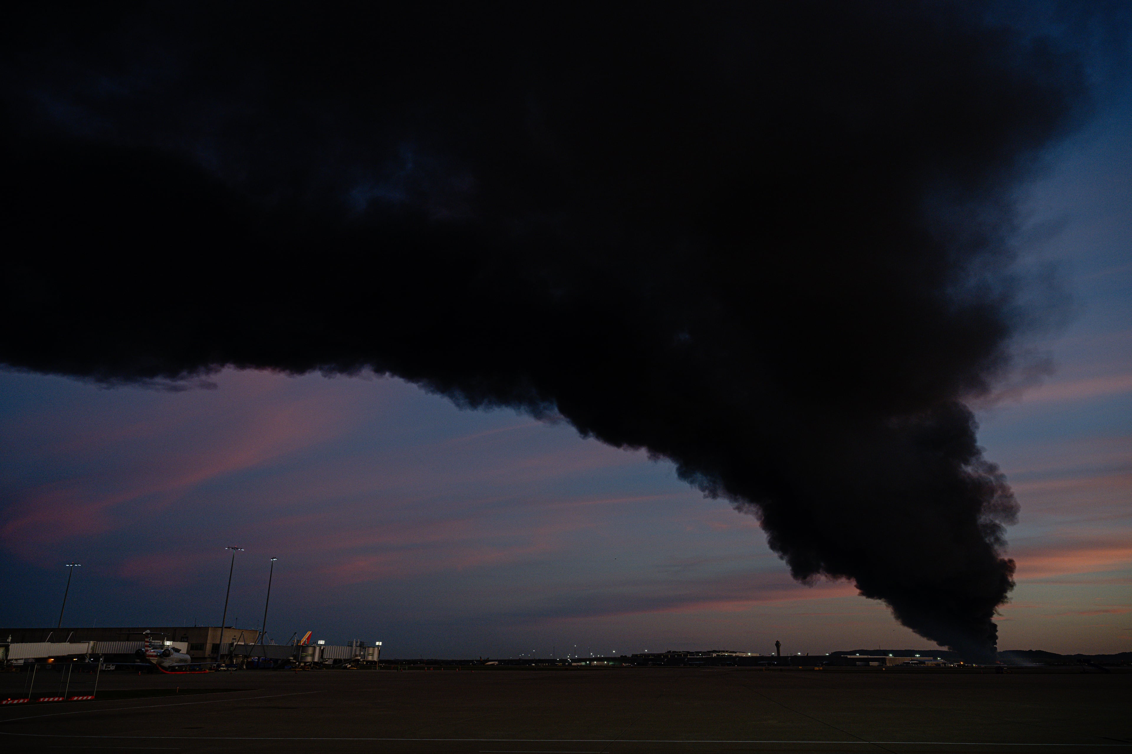 A plume of smoke wafts over airport property after the plane crash at Louisville International Airport on Tuesday, Nov. 4, 2025, in Louisville, Ky. (Jon Cherry/AP)