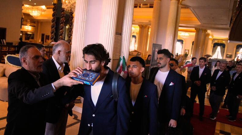 Iran's players kiss the Muslim's holiest book Quran as they leave to Antalya airport, southern Turkey, Saturday, June 6, 2026, before departing to Tijuana, Mexico, for the World Cup soccer tournament. (AP Photo/Khalil Hamra)