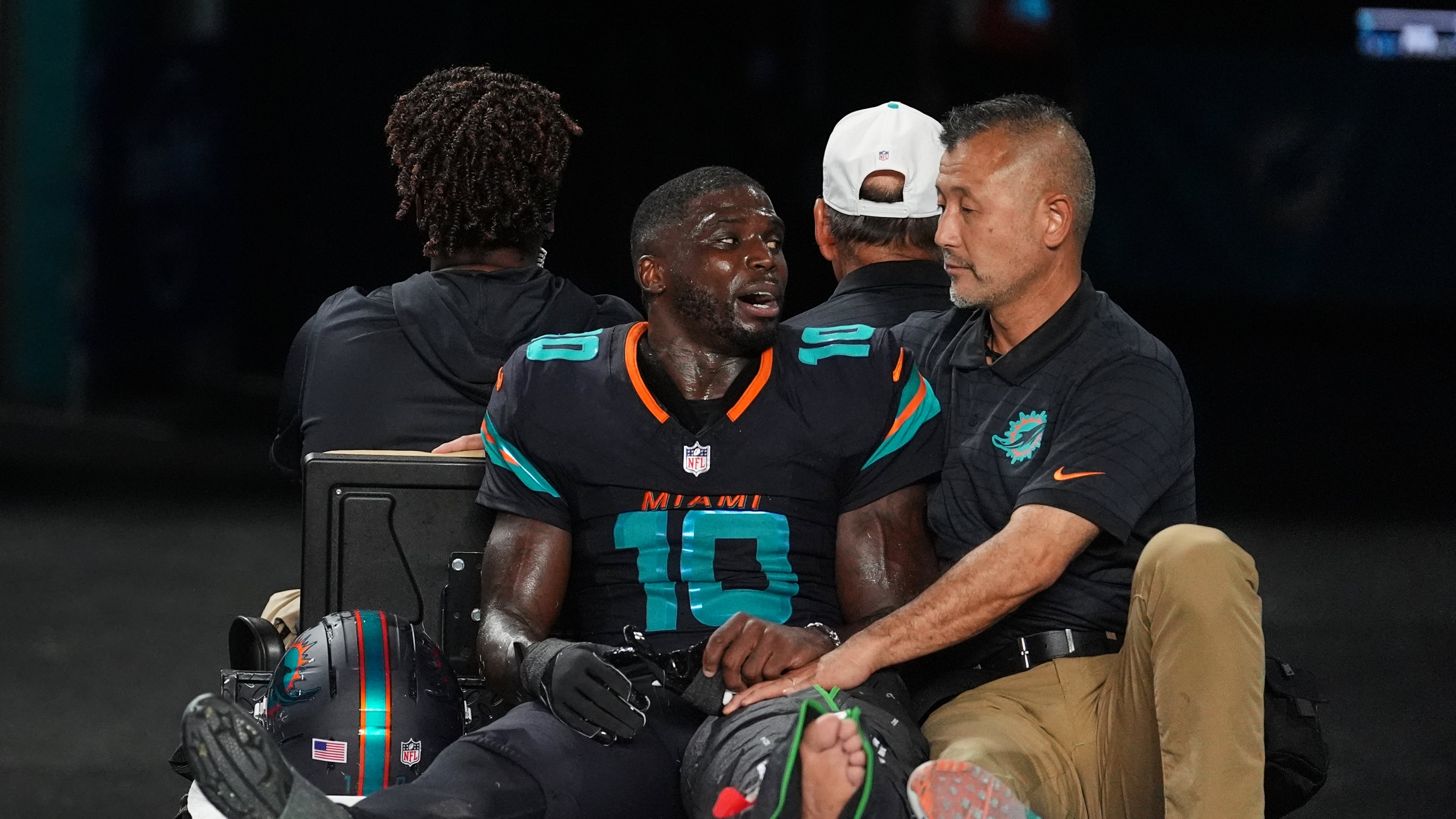 Miami Dolphins wide receiver Tyreek Hill (10) talks with a staff member as he is carted off the field after suffering an unknown lower leg injury in the second half of an NFL football game against the New York Jets, Monday, Sept. 29, 2025, in Miami Gardens, Fla. (AP Photo/Rebecca Blackwell)