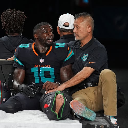 Miami Dolphins wide receiver Tyreek Hill (10) talks with a staff member as he is carted off the field after suffering an unknown lower leg injury in the second half of an NFL football game against the New York Jets, Monday, Sept. 29, 2025, in Miami Gardens, Fla. (AP Photo/Rebecca Blackwell)