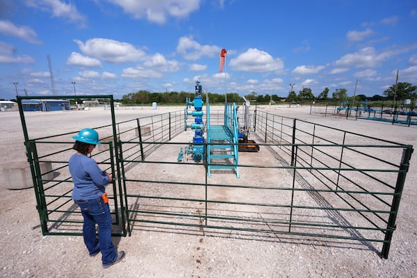 BKV Carbon Ventures senior facility engineer Laura Mamazza closes a gate on a carbon sequestration injection well pad site at a carbon capture and sequestration facility in Bridgeport, Texas, Thursday, May 29, 2025. (AP Photo/LM Otero)