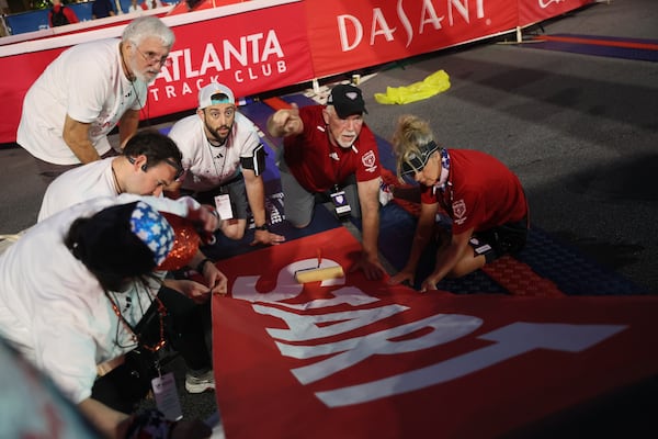 Volunteers get ready for the start of the 2023 Peachtree Road Race. (Arvin Temkar/AJC)