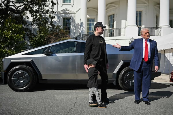 Tesla CEO Elon Musk (left), along with his son X Æ A-Xii, and President Donald Trump stand next to a Tesla vehicle while speaking to reporters on the South Lawn of the White House on Tuesday, March 11, 2025, in Washington. (AP Pool)