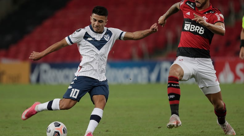Thiago Almada of Argentina's Velez Sarsfield (left) and Gustavo Henrique of Brazil's Flamengo battle for the ball during a Copa Libertadores soccer match Thursday, May 27, 2021, in Rio de Janeiro, Brazil. (Antonio Lacerda/AP)