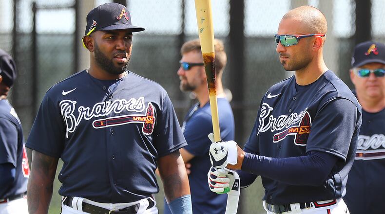 Braves outfielder Nick Markakis (right) checks out new teammate Marcell Ozuna's bat during batting practice Tuesday, Feb. 18, 2020, at CoolToday Park in North Port, Fla.