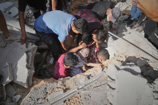EDS NOTE: GRAPHIC CONTENT - The body of a man is recovered from the rubble of a house following an Israeli military strike in Gaza City, Tuesday, July 15, 2025. (AP Photo/Jehad Alshrafi)