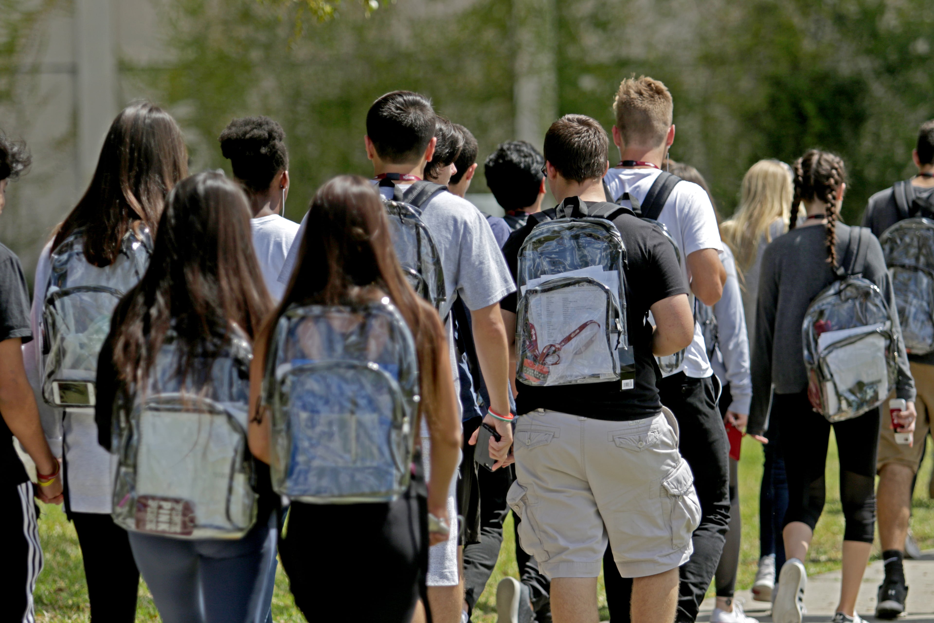 Students wear clear backpacks outside Marjory Stoneman Douglas High School in Parkland, Florida, on April 2, 2018. The bags are one of a number of security measures the school district enacted as a result of the shooting at the school that killed 17. (John McCall/Sun Sentinel)