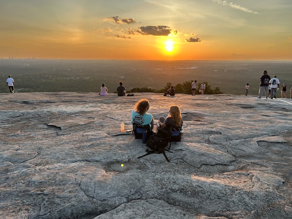 Jim Ennis, left, and Tamara Hamilton's first date had been at Rev Coffee in Smyrna. The second date had involved kayaks somewhere near Lake Allatoona. On the third date, they were singing, “Will you buy me a house of gold?” atop Stone Mountain. (Thomas Lake/AJC)