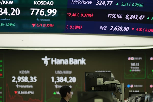 A dealer watches his computer monitors near the screens showing the Korea Composite Stock Price Index (KOSPI), left, and the foreign exchange rate between U.S. dollar and South Korean won at a dealing room of Hana Bank in Seoul, South Korea, Thursday, June 19, 2025. (AP Photo/Lee Jin-man)