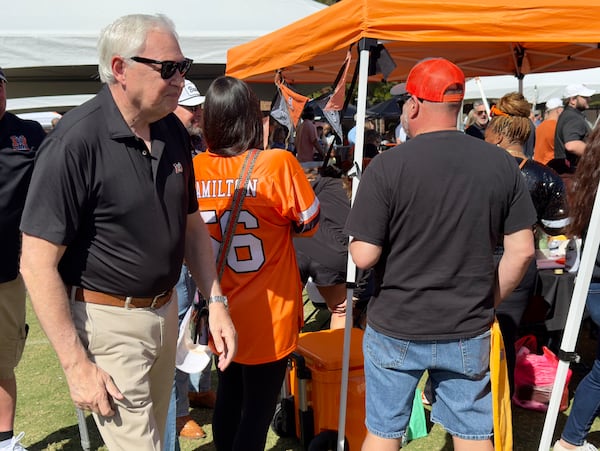 Mercer University's president, William D. "Bill" Underwood, walks among tailgaters before a recent football game on the school's main campus in Macon. (Joe Kovac Jr./AJC)