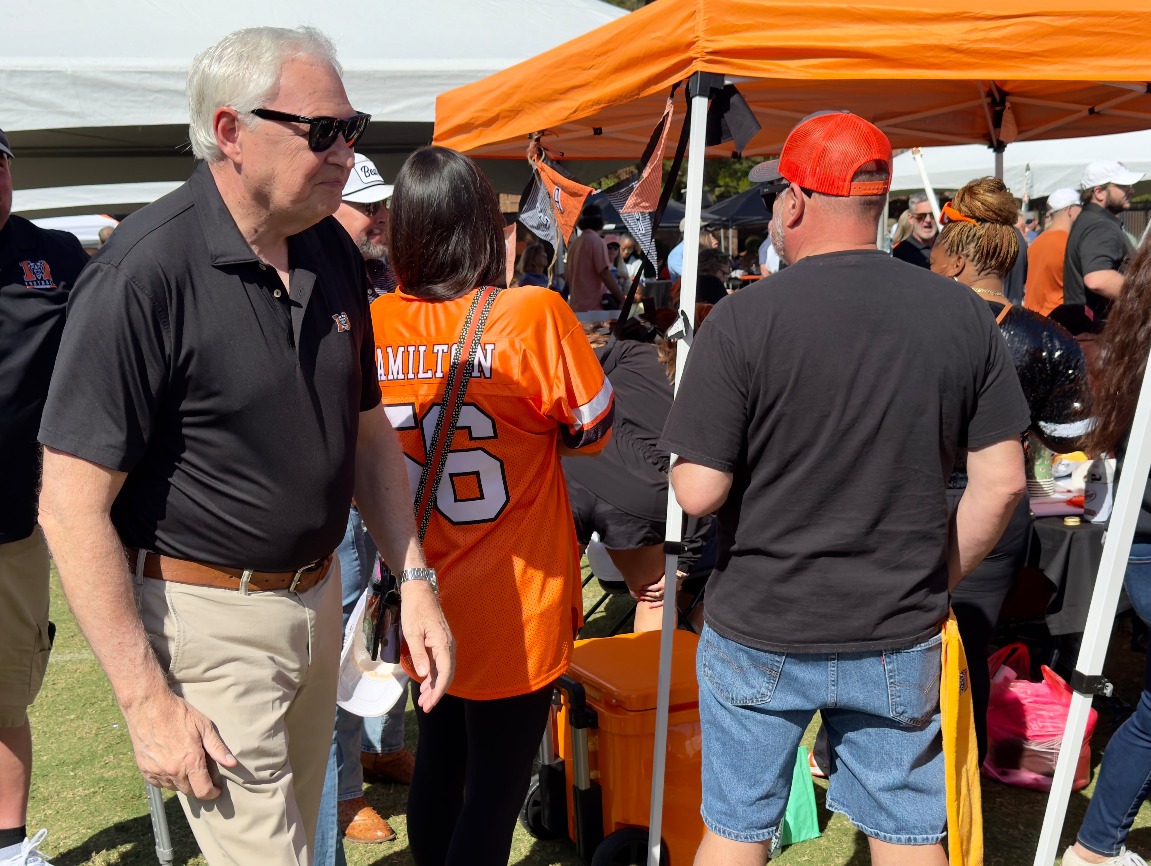 Mercer University's president, William D. "Bill" Underwood, walks among tailgaters before a recent football game on the school's main campus in Macon. (Joe Kovac Jr./AJC)