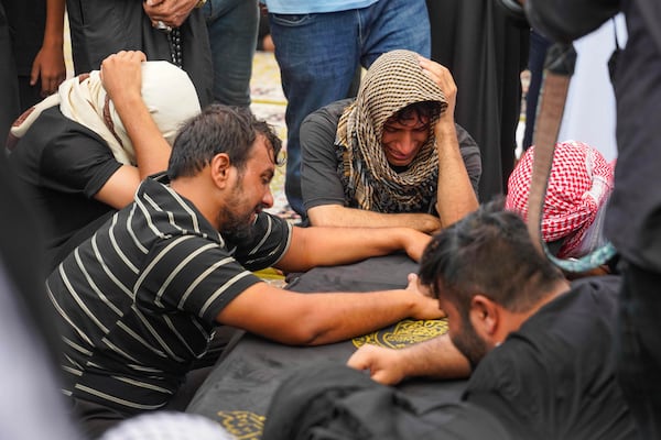 Mourners attend the funeral of victims who died in a fire at a shopping center in Kut, at the shrine of Imam Ali in Najaf, Iraq, Thursday, July 17, 2025. (AP Photo/Anmar Khalil)