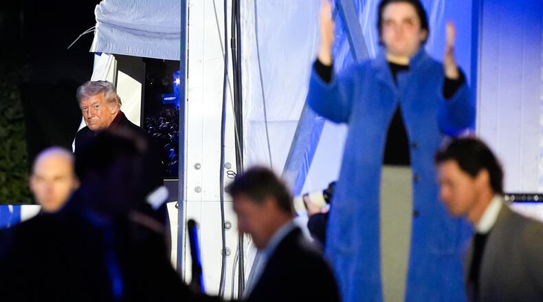 An American Sign Language interpreter, right, signs as President Donald Trump arrives for the lighting of the National Christmas Tree on the Ellipse, Thursday, Dec. 4, 2025, near the White House in Washington. (AP Photo/Julia Demaree Nikhinson)