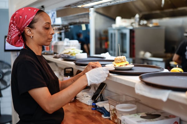 Erika Council, founder and owner of Bomb Biscuit in Atlanta, waits for orders at the restaurant on Thursday, Nov. 20, 2025. (Natrice Miller/AJC)