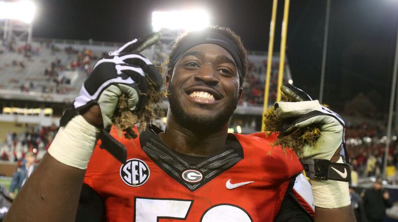 Georgia defensive end Sterling Bailey (58) celebrates with hands full of grass after Georgia defeated Georgia Tech in double overtime 41-34 on Saturday, November 30, 2013, at Bobby Dodd Stadium in Atlanta.