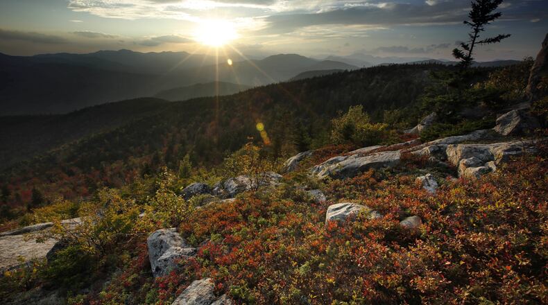In this Wednesday, Sept. 27, 2017 photo the sun begins to set in this view from South Moat Mountain in Albany, N.H. Despite forecasts for brilliant foliage throughout the Northeast this year, long-time leaf watchers say the leaves this fall are dull and weeks behind schedule in their turn from green to the brilliant hues of autumn. (AP Photo/Robert F. Bukaty)