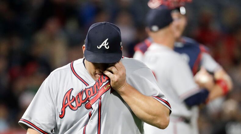 Braves starting pitcher Bartolo Colon wipes his face as he leaves the field after giving up ninth runs to the Los Angeles Angels during the third inning. (AP Photo/Chris Carlson)