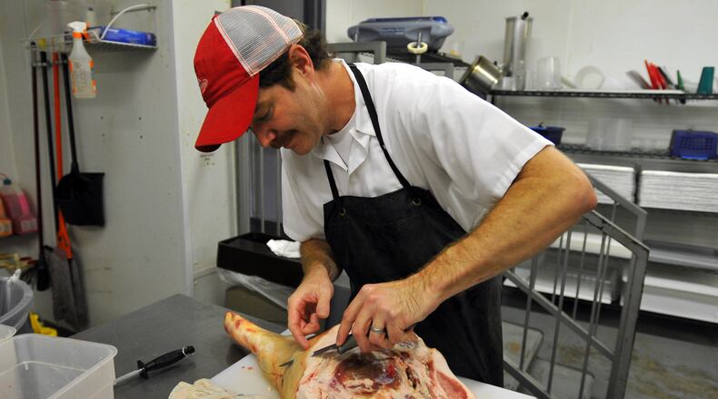 Rusty Bowers, owner of Pine Street Market, works at the Avondale Estates store. Brant Sanderlin bsanderlin@ajc.com