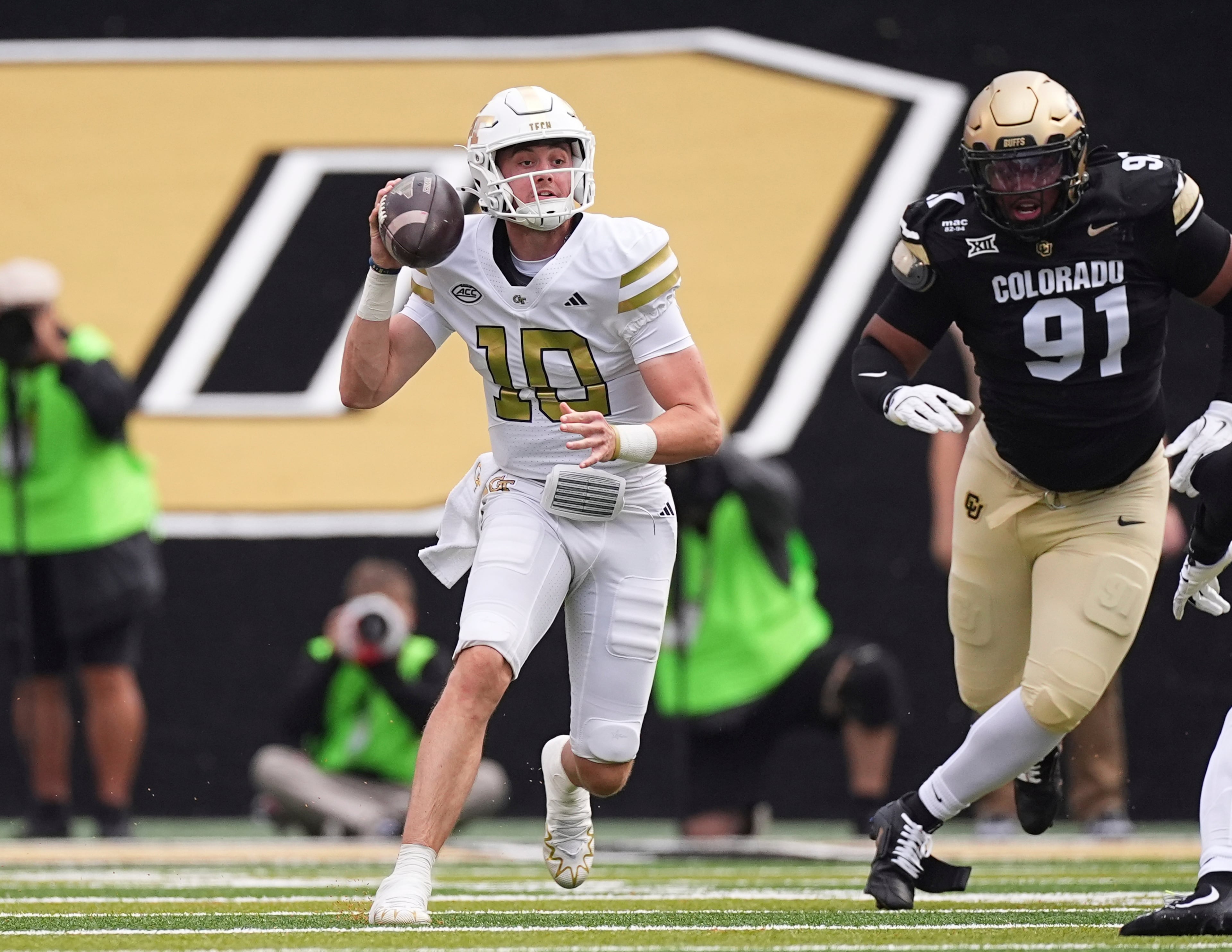 Georgia Tech quarterback Haynes King, left, looks to pass the ball as Colorado defensive end Brandon Davis-Swain pursues in the first half of an NCAA college football game Friday, Aug. 29, 2025, in Boulder, Colo. (AP Photo/David Zalubowski)