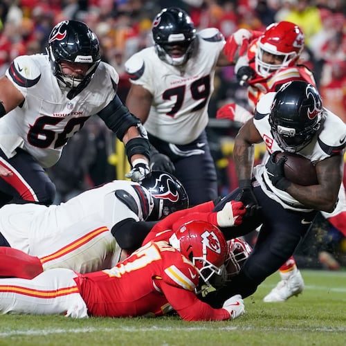 Houston Texans running back Dare Ogunbowale, right, scores past Kansas City Chiefs defensive back Chamarri Conner during the second half of an NFL football game Wednesday, Jan. 7, 2026, in Kansas City, Mo. (AP Photo/Ed Zurga)