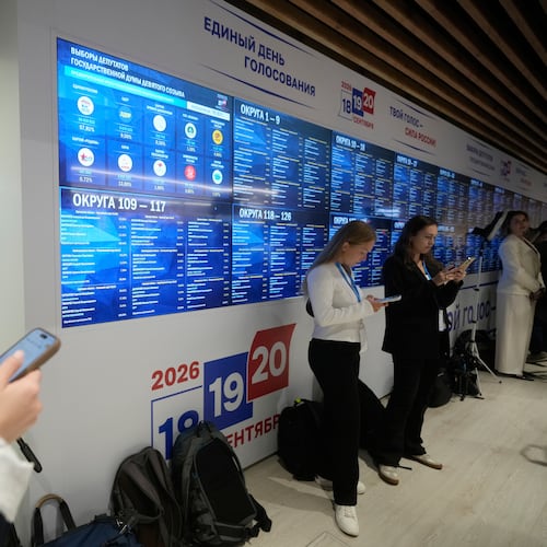 Journalists stand next to video screens sowing preliminary voting results for Russian parliamentary elections at Russia's Central Election Committee headquarters, in Moscow, Russia, Monday, Sept. 21, 2026. (AP Photo/Pavel Bednyakov)