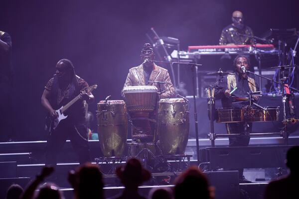 Philip Bailey (center), on congas and lead vocals, is one of the last original Earth, Wind & Fire members still with the band, which performed at State Farm Arena on Sunday, July 19, 2026. (Akili-Casundria Ramsess for the AJC)