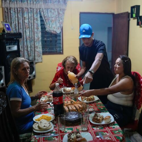 Mariela Gómez, right, and her partner Abraham Castro, a Venezuelan migrant couple, sit for Christmas dinner at Castro's parents' home in Maracay, Venezuela, early Thursday, Dec. 25, 2025. The couple abandoned their journey to the United States and returned home from Mexico by land and sea following President Donald Trump's immigration crackdown. (AP Photo/Matias Delacroix)