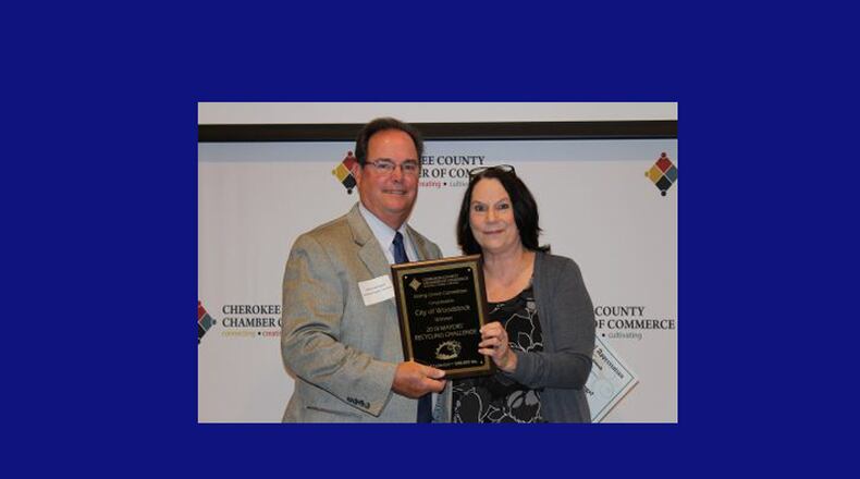 Woodstock Mayor Donnie Henriques (left) accepts the Mayors’ Challenge award from Going Green Chairman Nancy Wesselink for most recycling collected in the Cherokee County Chamber of Commerce Mayor’s Recycling Challenge.