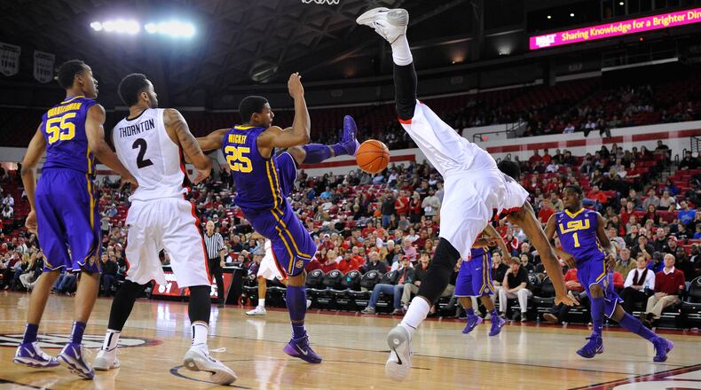 Georgia guard Charles Mann (4) goes off balance attempting a shot while defended by LSU forward Jordan Mickey (25) during the second half of an NCAA college basketball game on Thursday, Feb. 6, 2014 in Athens, Ga. Georgia won 91-78. Mann was injured on the play but returned later in the game. (AP Photo/Athens Banner-Herald, AJ Reynolds)