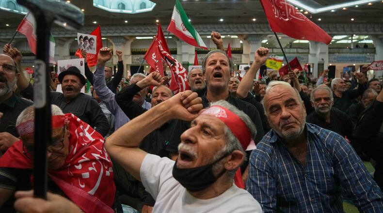Mourners chant as they raise their fists during a gathering commemorating the late Supreme Leader Ali Khamenei at the Imam Khomeini Mosalla Grand Mosque in Tehran, Iran, Tuesday, July 14, 2026. (AP Photo/Vahid Salemi)
