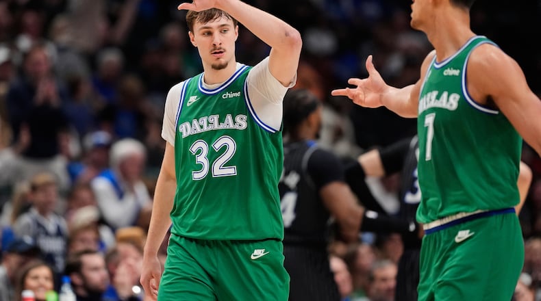 Dallas Mavericks forward Cooper Flagg (32) and Dwight Powell, right, celebrate a basket by Flagg in the second half of an NBA basketball game against the Orlando Magic Friday, April 3, 2026, in Dallas. (AP Photo/Tony Gutierrez)