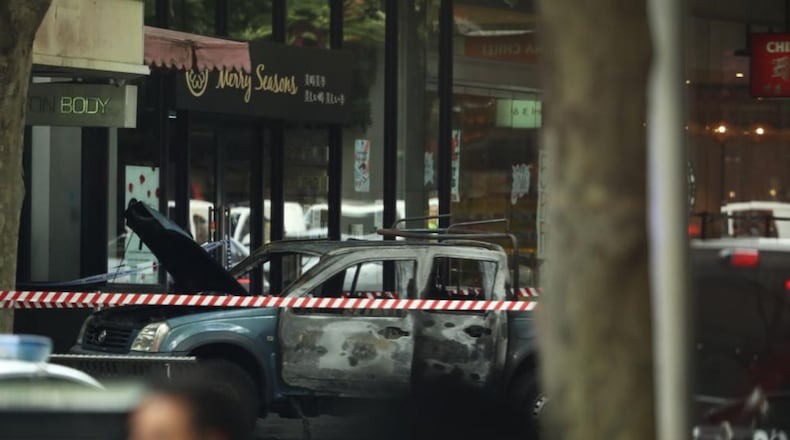 A burned vehicle is shown in the central Melbourne shopping district after a stabbing took place Friday.