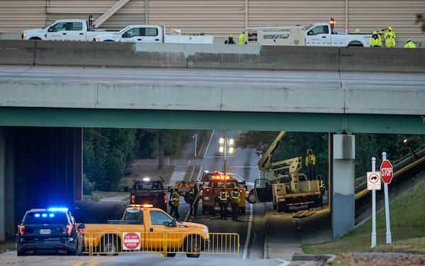 Meadowbrook Lane is closed in both directions after a hole opened on I-75's bridge over the road. (Ben Hendren for the AJC)