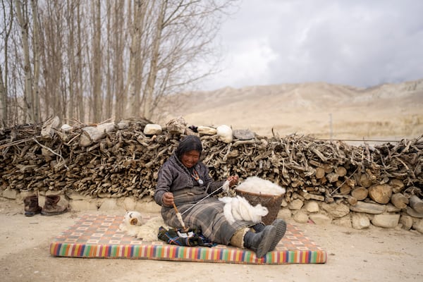 A woman makes thread from cotton at a relocated settlement of the abandoned Samjung village in the Mustang region, 462 kilometers west of Kathmandu, Nepal, Saturday, April 19, 2025. (AP Photo/Niranjan Shrestha)