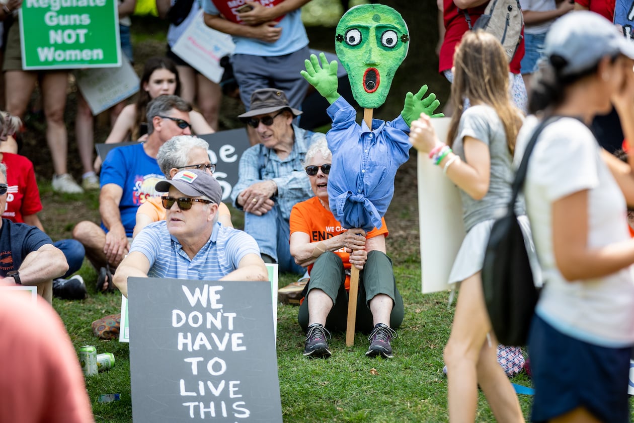 Susanne Fincher (Center) holds up her sign before the start of a rally organized by Georgia Moms Demand Action in Piedmont Park on Saturday, May 13, 2023. The rally was part of a national series of protests the day before Mother’s Day to highlight the mounting toll of gun violence. (Steve Schaefer/steve.schaefer@ajc.com)