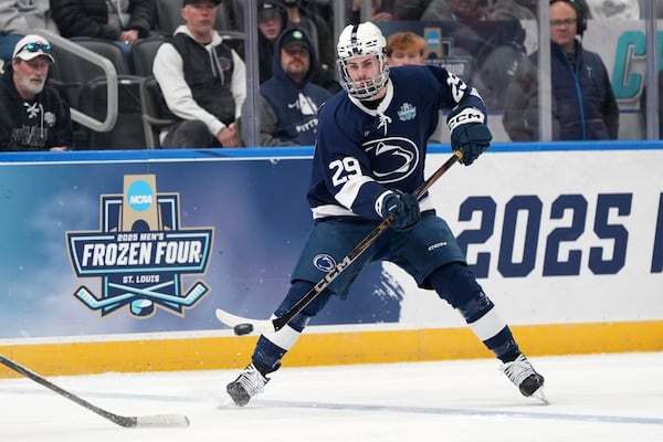 Penn State's Reese Laubach passes the puck during the first period in a semifinal game in the NCAA Frozen Four men's college hockey tournament against Boston University, Thursday, April 10, 2025, in St. Louis (AP Photo/Jeff Roberson)