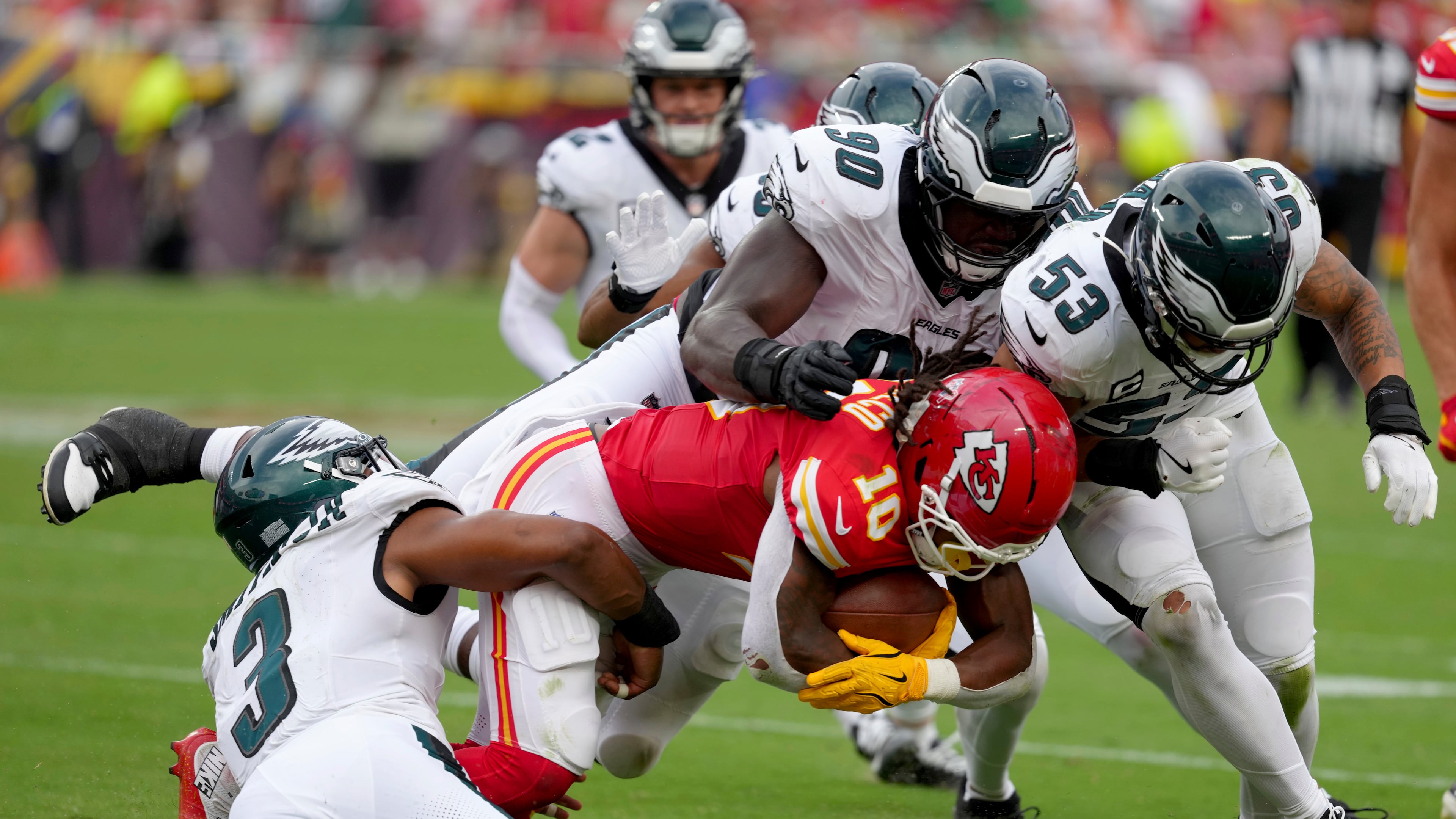 Kansas City Chiefs running back Isiah Pacheco (10) is tackled by Philadelphia Eagles' Nolan Smith (3), Jordan Davis (90) and Zack Baun (53) during the second half of an NFL football game Sunday, Sept. 14, 2025, in Kansas City, Mo. (AP Photo/Ed Zurga)