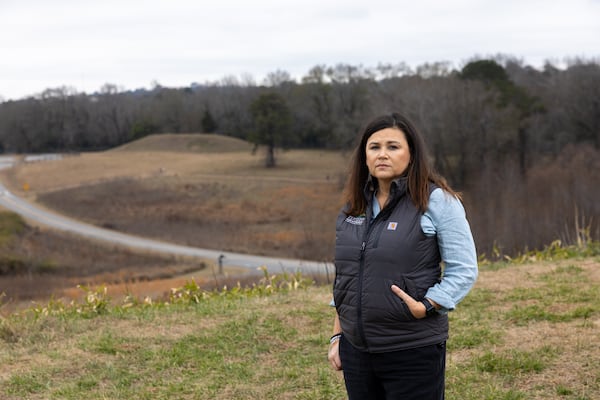 Tracie Revis, acting CEO of the Ocmulgee National Park and Preserve Initiative, stands atop Great Temple Mound. (Arvin Temkar/AJC)