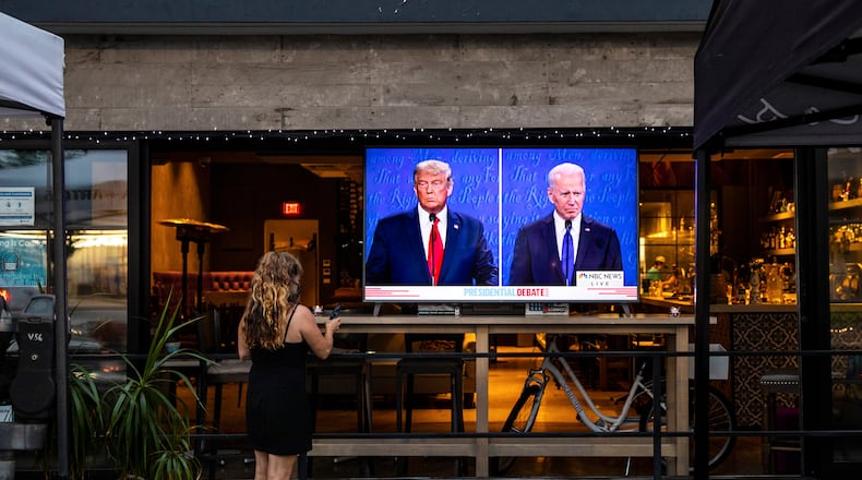 A server in Hermosa Beach, Calif., turns up the volume on the Oct. 22, 2020, U.S. presidential debate between Republican President Donald J. Trump and former Democratic Vice President Joe Biden. (Jay L. Clendenin/Los Angeles Times/TNS)