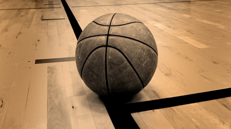 Basketball on court with hoop in the background ** Note: Shallow depth of field