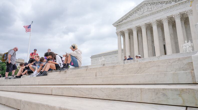 Visitors sit on the steps of the U.S. Supreme Court, Monday, June 8, 2026, in Washington. (AP Photo/Mariam Zuhaib)