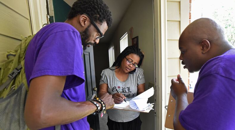 New Georgia Project volunteers help Rueke Uyunwa register to vote in May 2017. (File photo by HYOSUB SHIN / HSHIN@AJC.COM)