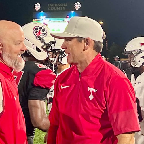 Jackson County coach Korey Mobbs, left, and North Oconee coach Tyler Aurandt, right, talk after a game on Sept. 12, 2026. (McClain Baxley for the AJC)
