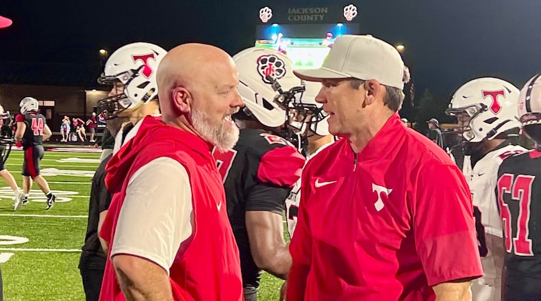 Jackson County coach Korey Mobbs, left, and North Oconee coach Tyler Aurandt, right, talk after a game on Sept. 12, 2026. (McClain Baxley for the AJC)