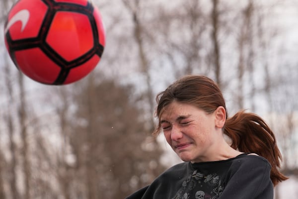 Parker Tirrell, a transgender athlete who plays on her high school's girls soccer team, heads the ball, Friday, March 7, 2025, in Plymouth, N.H. (AP Photo/Charles Krupa)