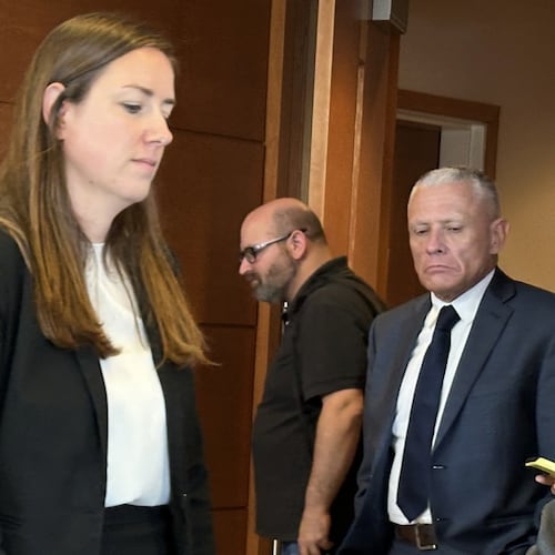 This photo taken with a smartphone shows defense attorney Delia McCarthy, left, and Jeffrey Buskey, center, charged with multiple counts of aggravated felonious sexual assault, leaving a courtroom during a break in Buskey's trial in Manchester, N.H., Monday, Sept. 14, 2026. (AP Photo/Holly Ramer)
