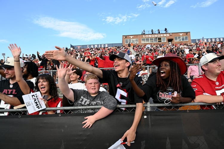 Football fans cheer as they watch their favorite players in action during the Atlanta Falcons' "Saturday Night Lights" practice Saturday, Aug. 8, 2026, at Lanier High School in Sugar Hill. (Hyosub Shin/AJC)