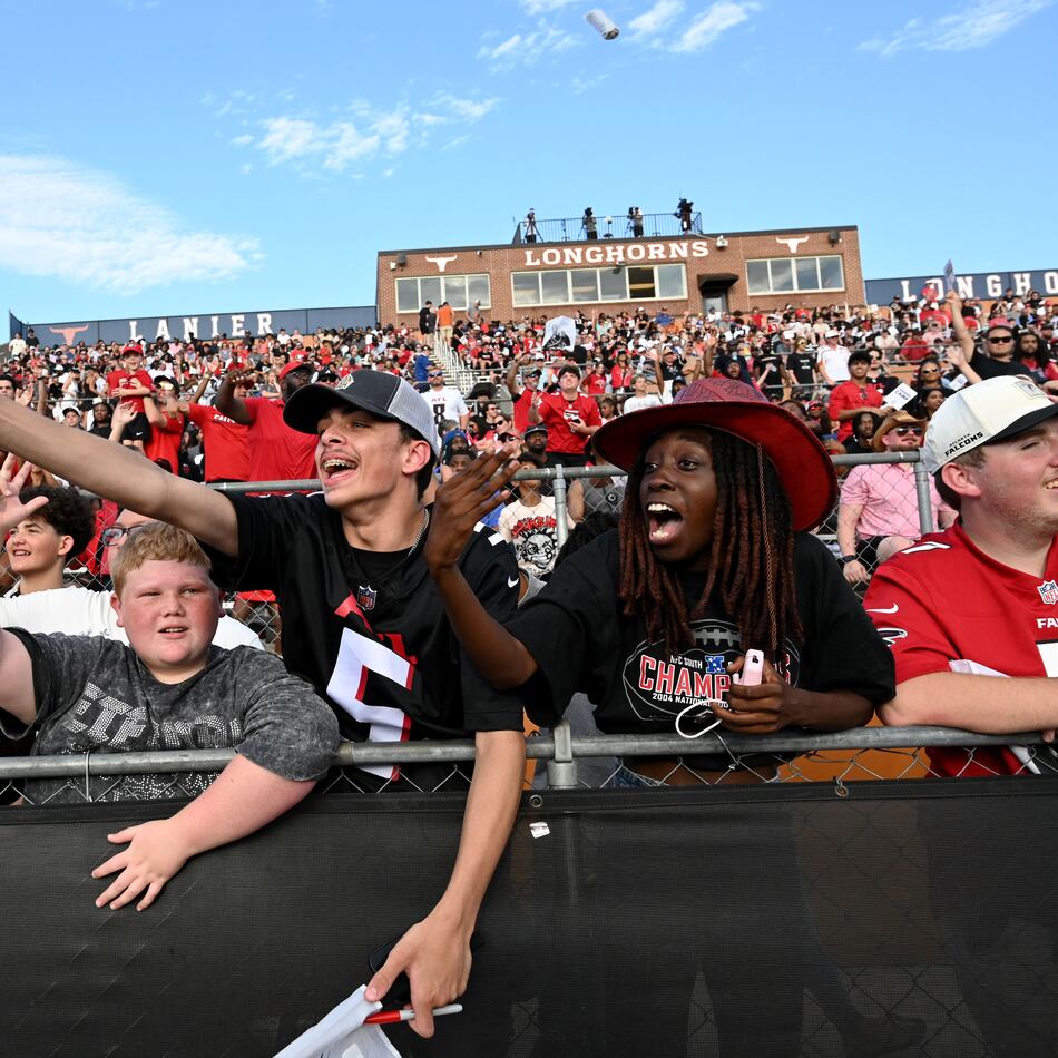 Football fans cheer as they watch their favorite players in action during the Atlanta Falcons' "Saturday Night Lights" practice Saturday, Aug. 8, 2026, at Lanier High School in Sugar Hill. (Hyosub Shin/AJC)